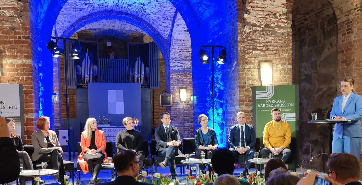 Puolueiden edustajat istuvat rinnakkain Helsingin tuomiokirkon krypassa