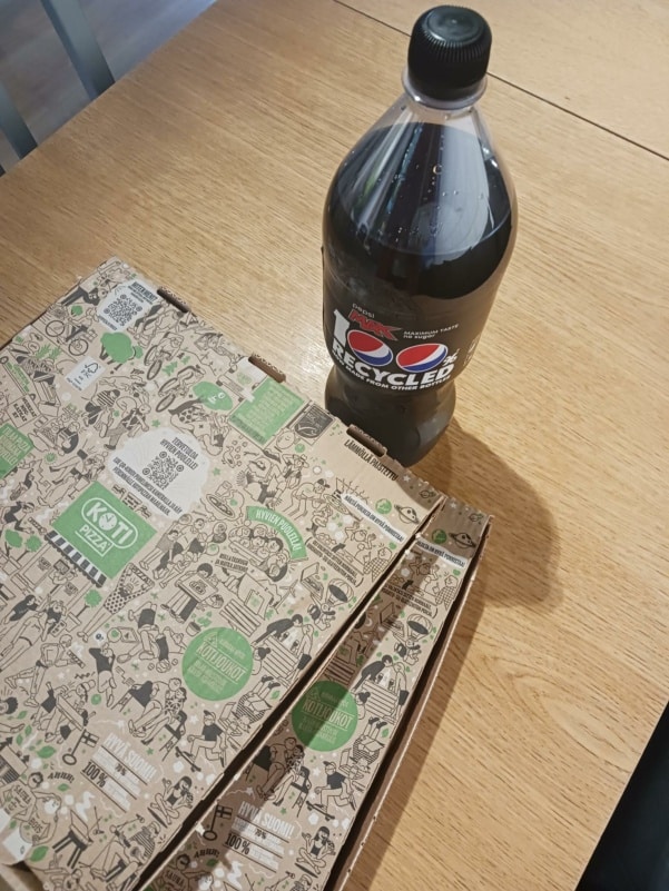 Pöydällä pizzalaatikoita ja pullo CocaColaa