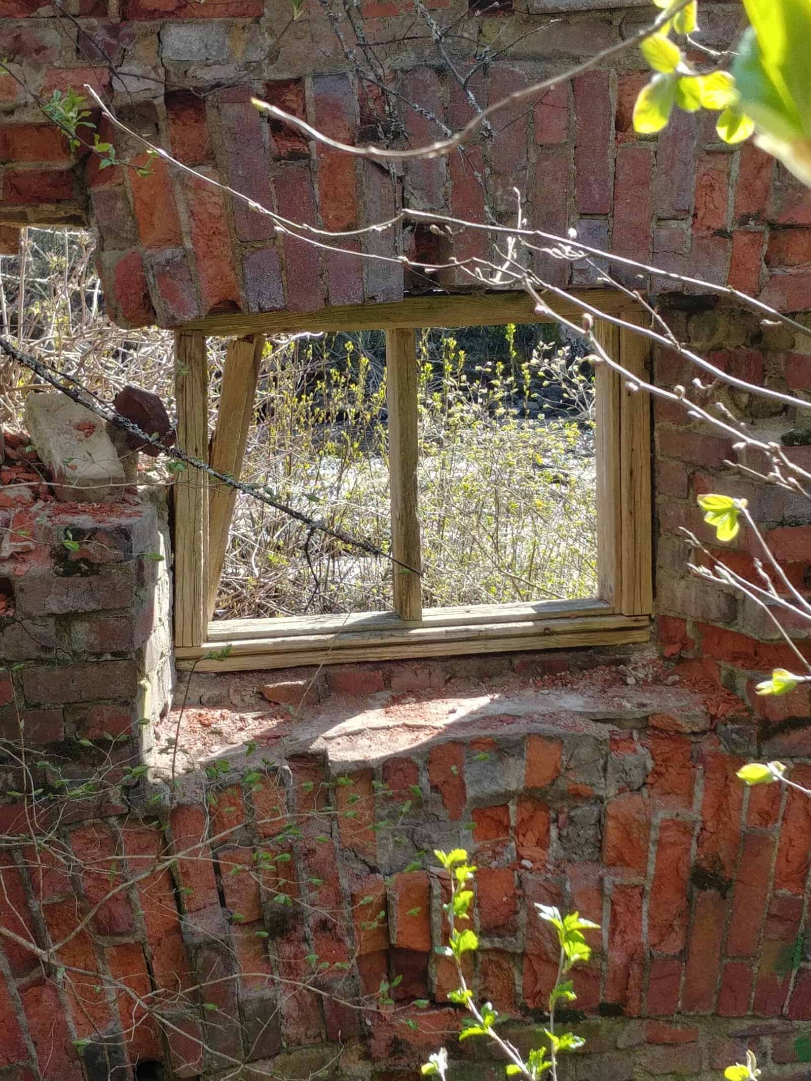 raunioitunut talon seinä, jossa ikkunan raamit
